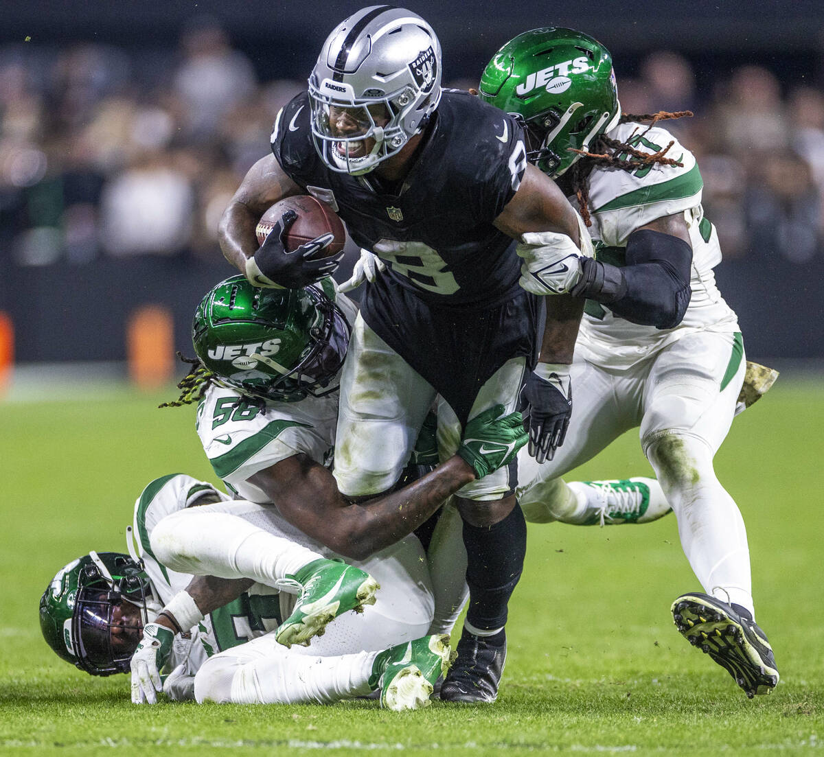 Raiders running back Josh Jacobs (8) is taken down after another first down by three New York J ...
