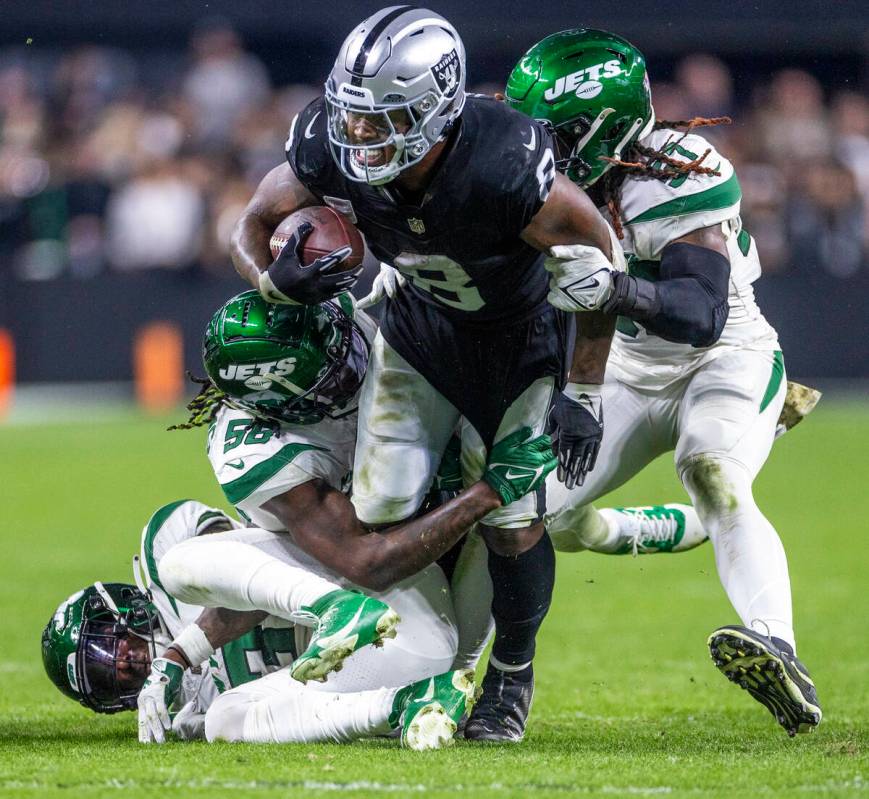 Raiders running back Josh Jacobs (8) is taken down after another first down by three New York J ...