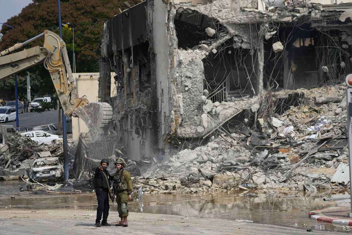 A digger removes the rubble from the police station that was overrun by Hamas militants on Satu ...