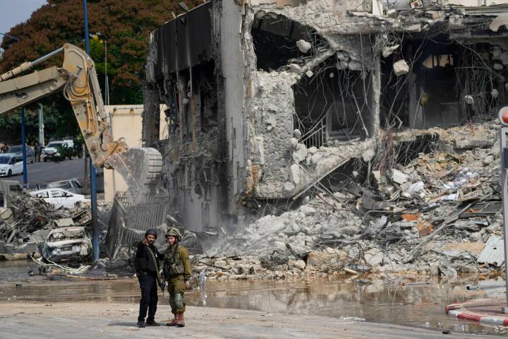 A digger removes the rubble from the police station that was overrun by Hamas militants on Satu ...