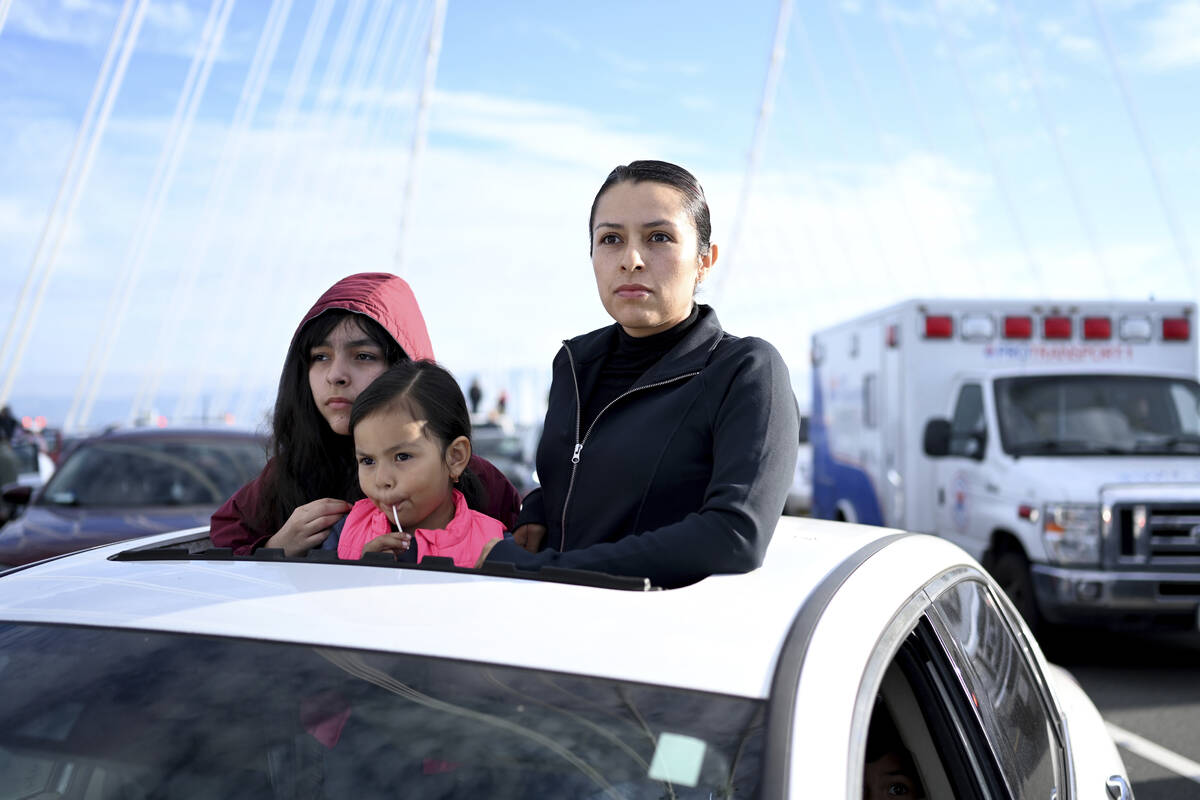 Elsa Santos and her children wait for police officers to clear protesters off the San Francisco ...