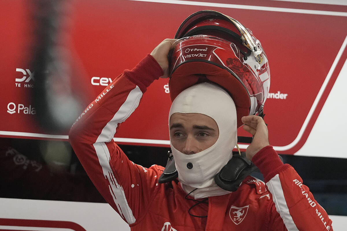Ferrari driver Charles Leclerc, of Monaco, puts on his helmet during the final practice session ...