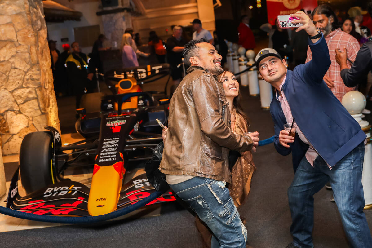 Strip tourists pose for a picture in front of a Red Bull Racing Formula 1 race car prior to the ...