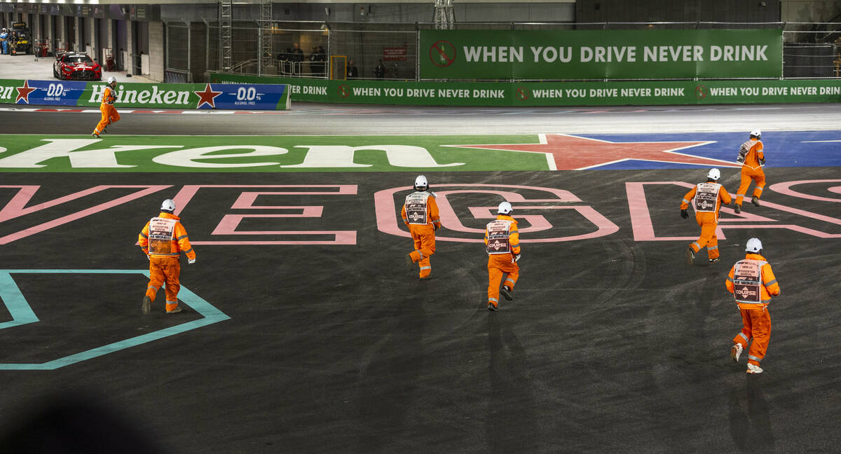 Intervention marshals run onto the course to pick up crash debris in turn one during the Las Ve ...
