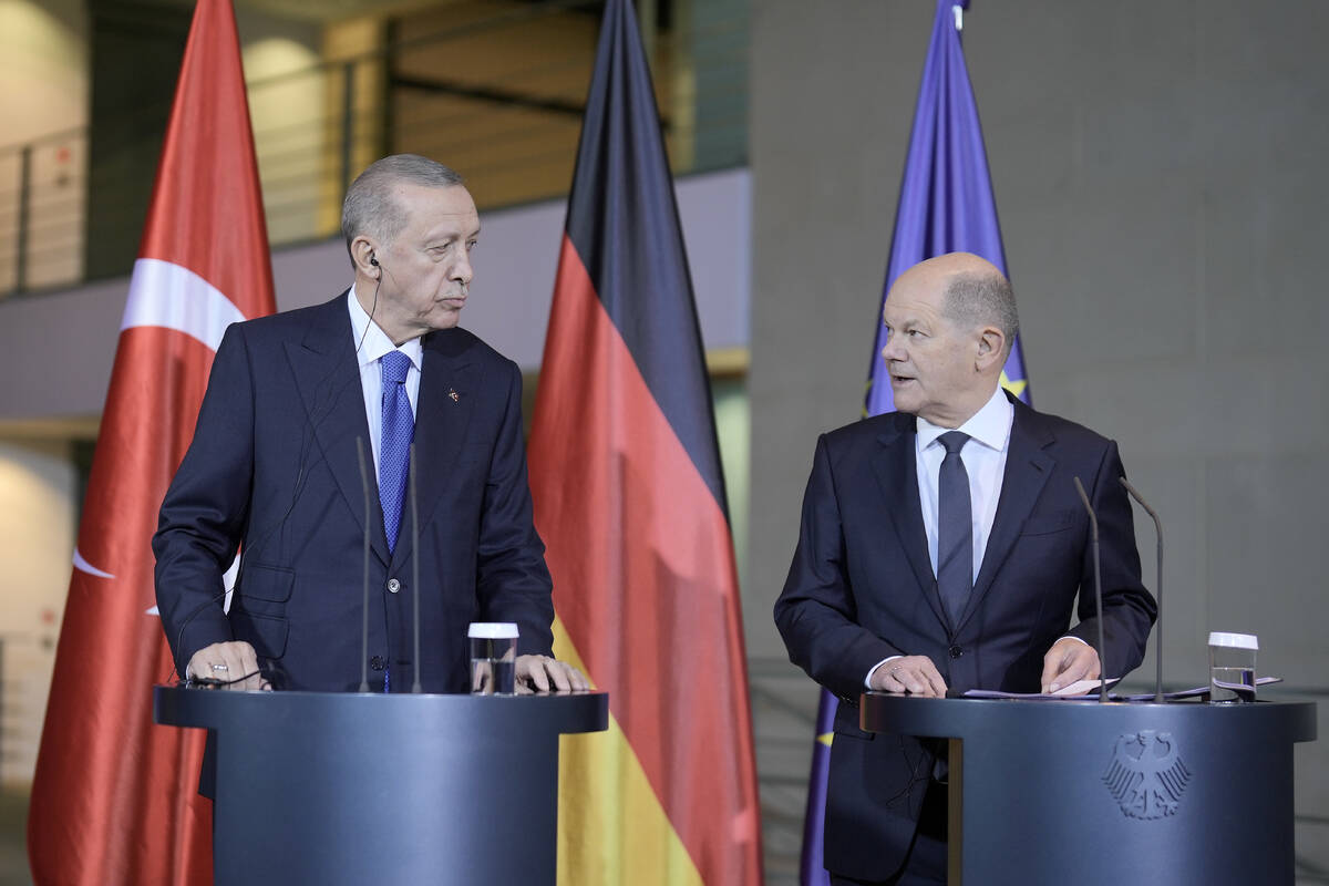 Turkey's President Recep Tayyip Erdogan, left, and German Chancellor Olaf Scholz talk to the me ...