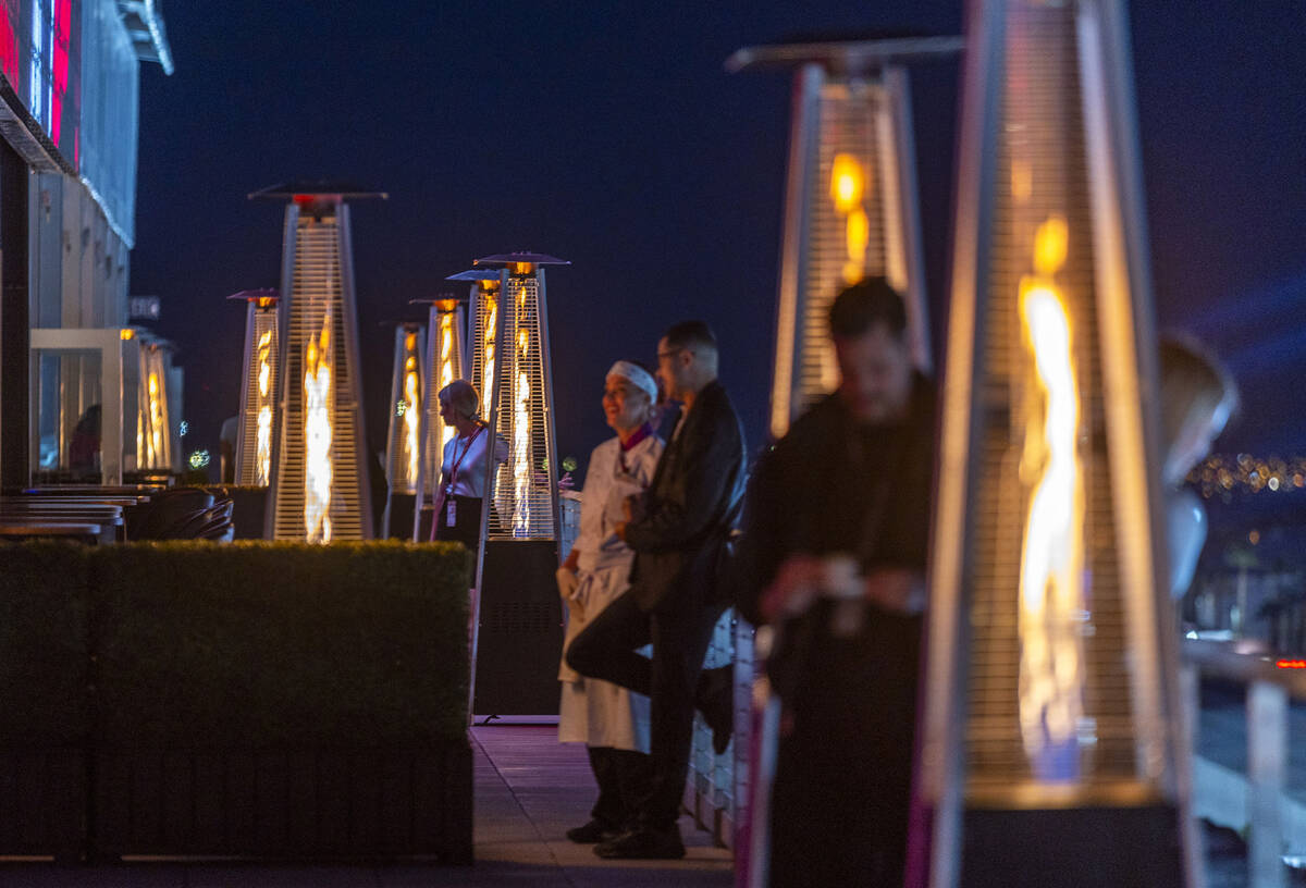 Heat lamps keep people warm on the paddock roof during on the final night of the Las Vegas Gran ...