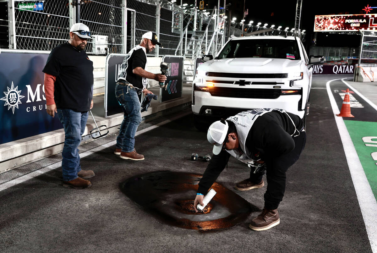 A crew from Las Vegas Paving inspects a valve cover to make sure it is secure and that the pave ...