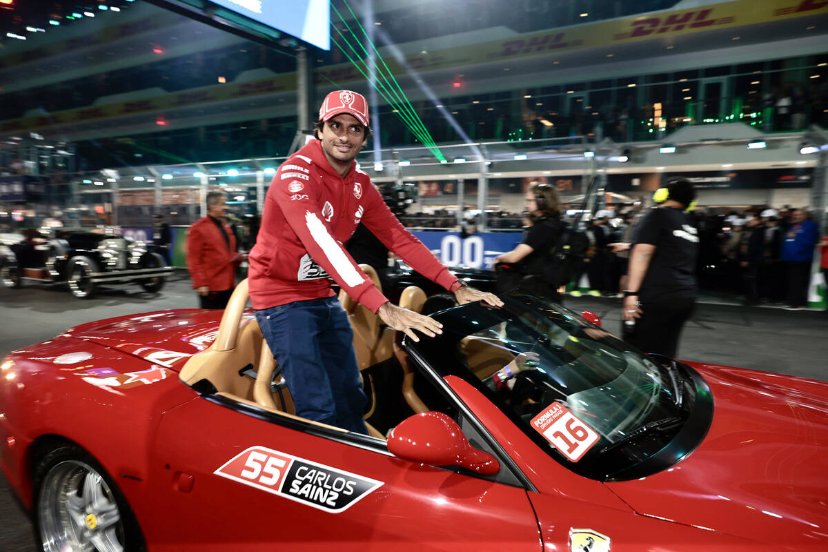 Team Ferrari driver Carlos Sainz holds on tight in a classic car while riding in the driver&#x2 ...