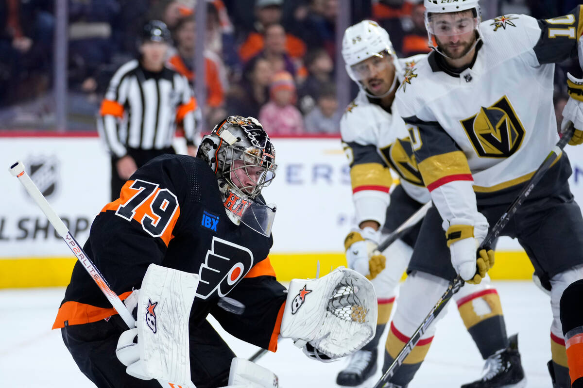 Philadelphia Flyers' Carter Hart, left, blocks a shot during the first period of an NHL hockey ...