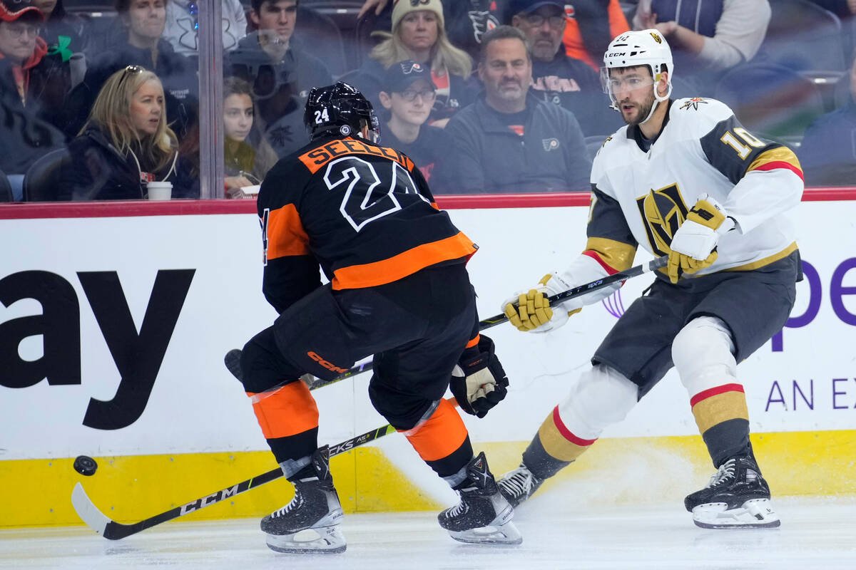 Vegas Golden Knights' Nicolas Roy, right, gets the puck past Philadelphia Flyers' Nick Seeler d ...