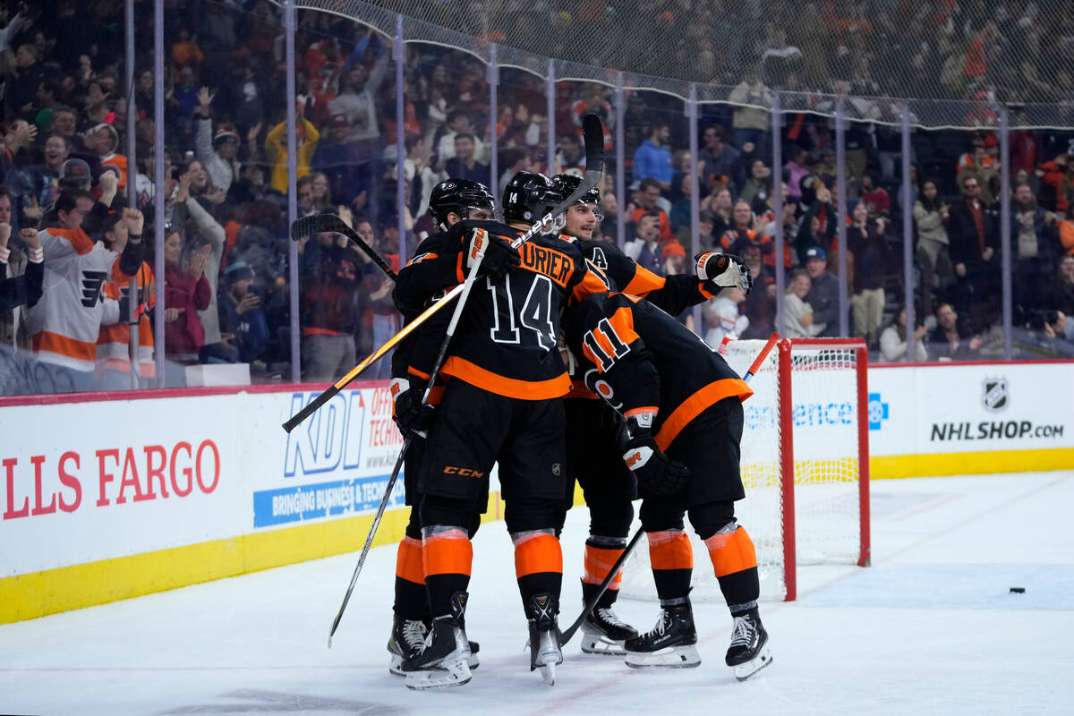 Philadelphia Flyers' Sean Couturier (14) celebrates with teammates after scoring the game-winni ...