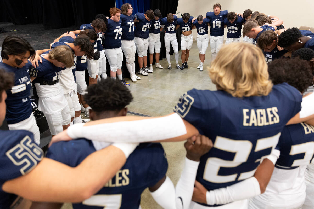 Lake Mead varsity players pray before their Class 2A high school football game against Lincoln ...