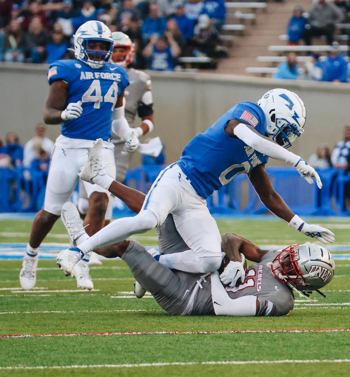 UNLV wide receiver Ricky White (11) falls with the ball as Air Force defensive back Trey Willia ...