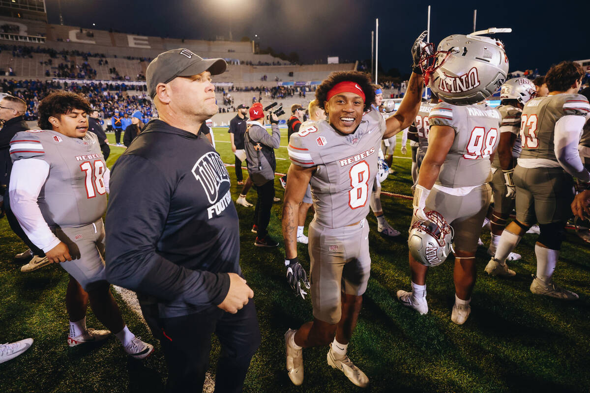 UNLV defensive lineman Darius Johnson (8) celebrates as he walks next to UNLV head coach Barry ...