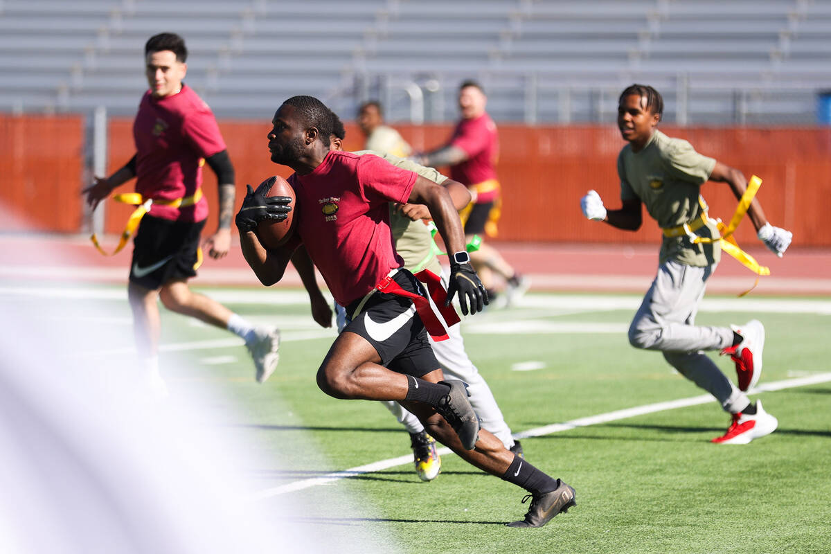 Officer Javhion Wood, representing the Henderson Police Department, runs the ball down the fiel ...