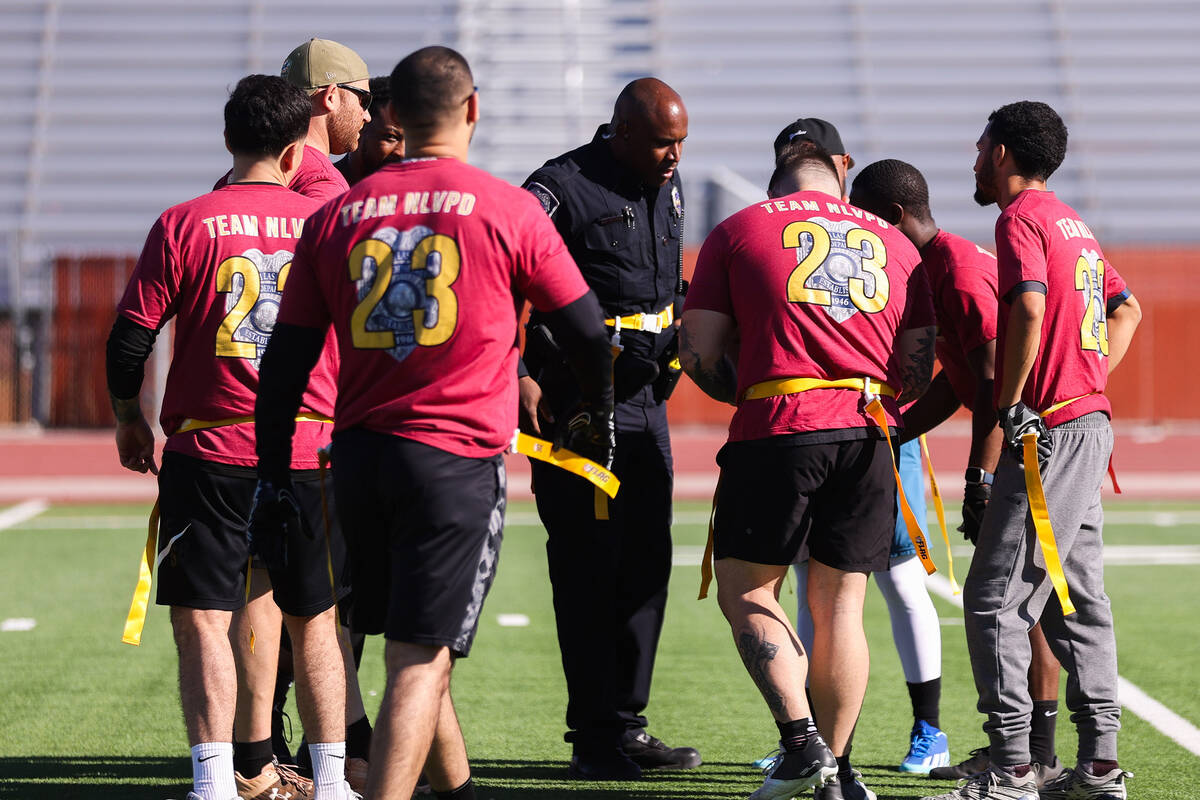 Sergeant Marcus Cook speaks with the rest of his team during the third annual Turkey Bowl betwe ...