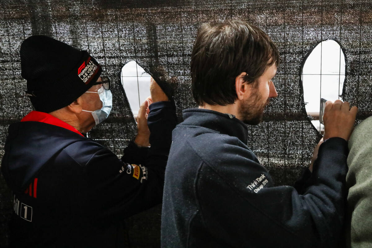 Fans cut holes into a fence netting to watch the final Formula 1 Las Vegas Grand Prix race on S ...
