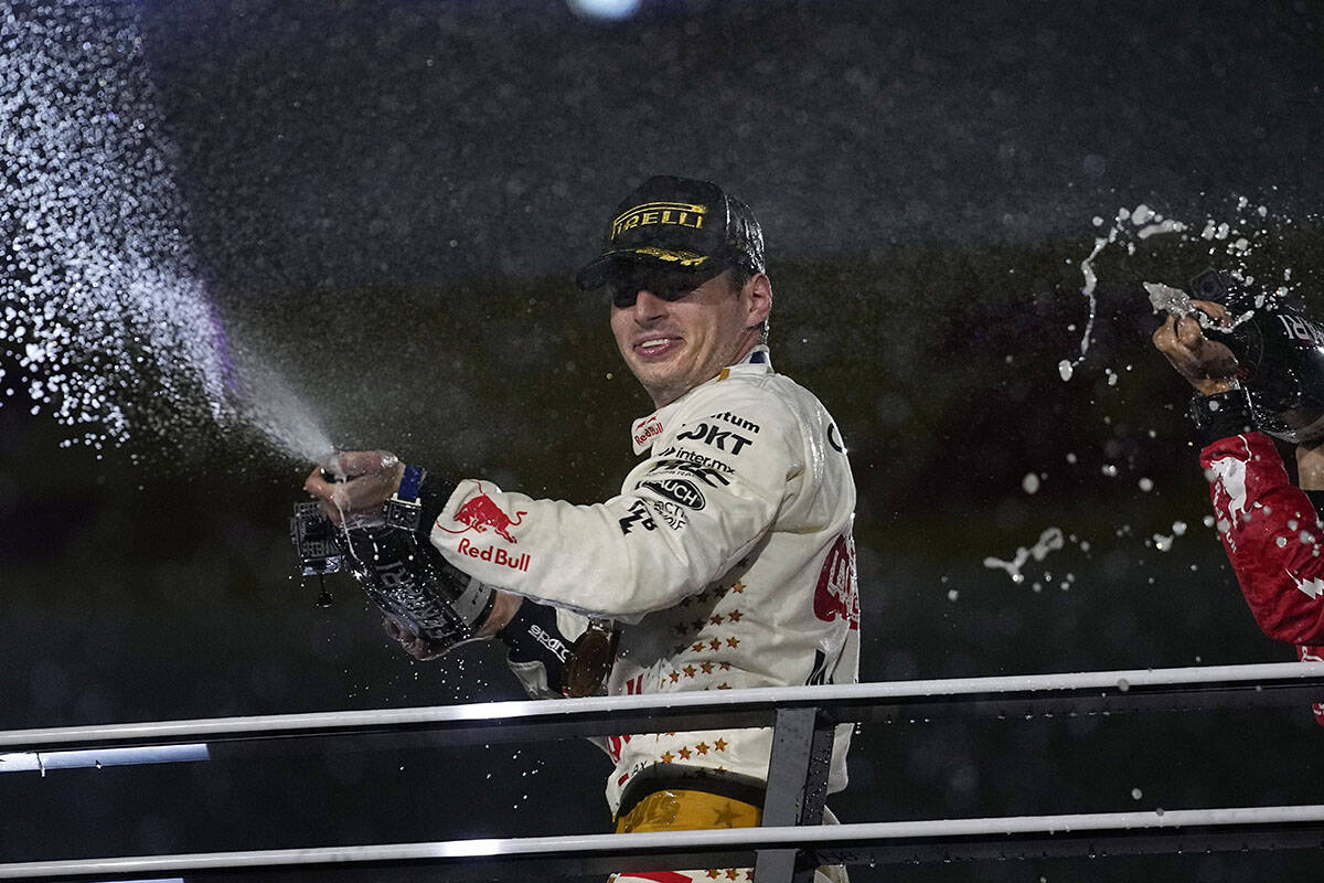 Red Bull driver Max Verstappen, of the Netherlands, sprays champagne on the podium after winnin ...