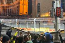 Fans tear down a screen meant to block views of the Las Vegas Grand Prix on Saturday. (Lorraine ...