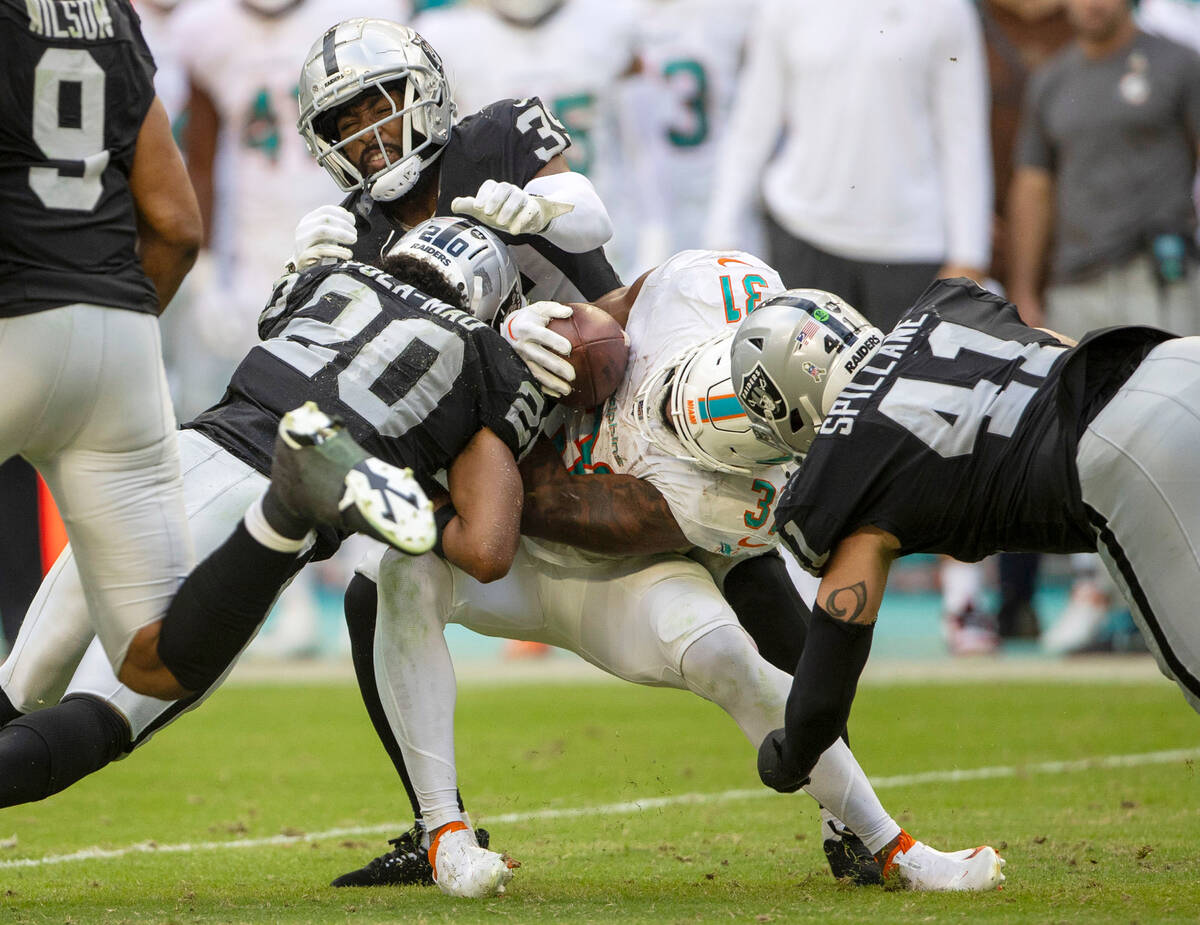 Miami Dolphins running back Raheem Mostert (31) is tackled by Raiders safety Isaiah Pola-Mao (2 ...