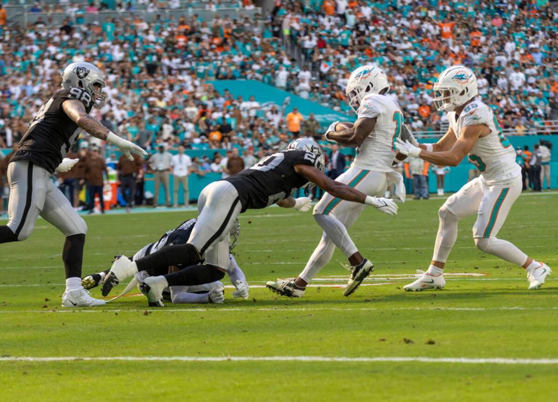 Raiders safety Isaiah Pola-Mao (20) stops Miami Dolphins wide receiver Tyreek Hill (10) on a fo ...