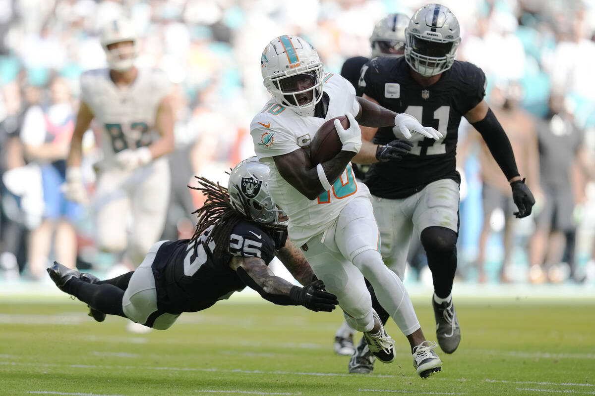 Miami Dolphins running back Raheem Mostert (31) is tackled by Las Vegas Raiders linebacker Robe ...