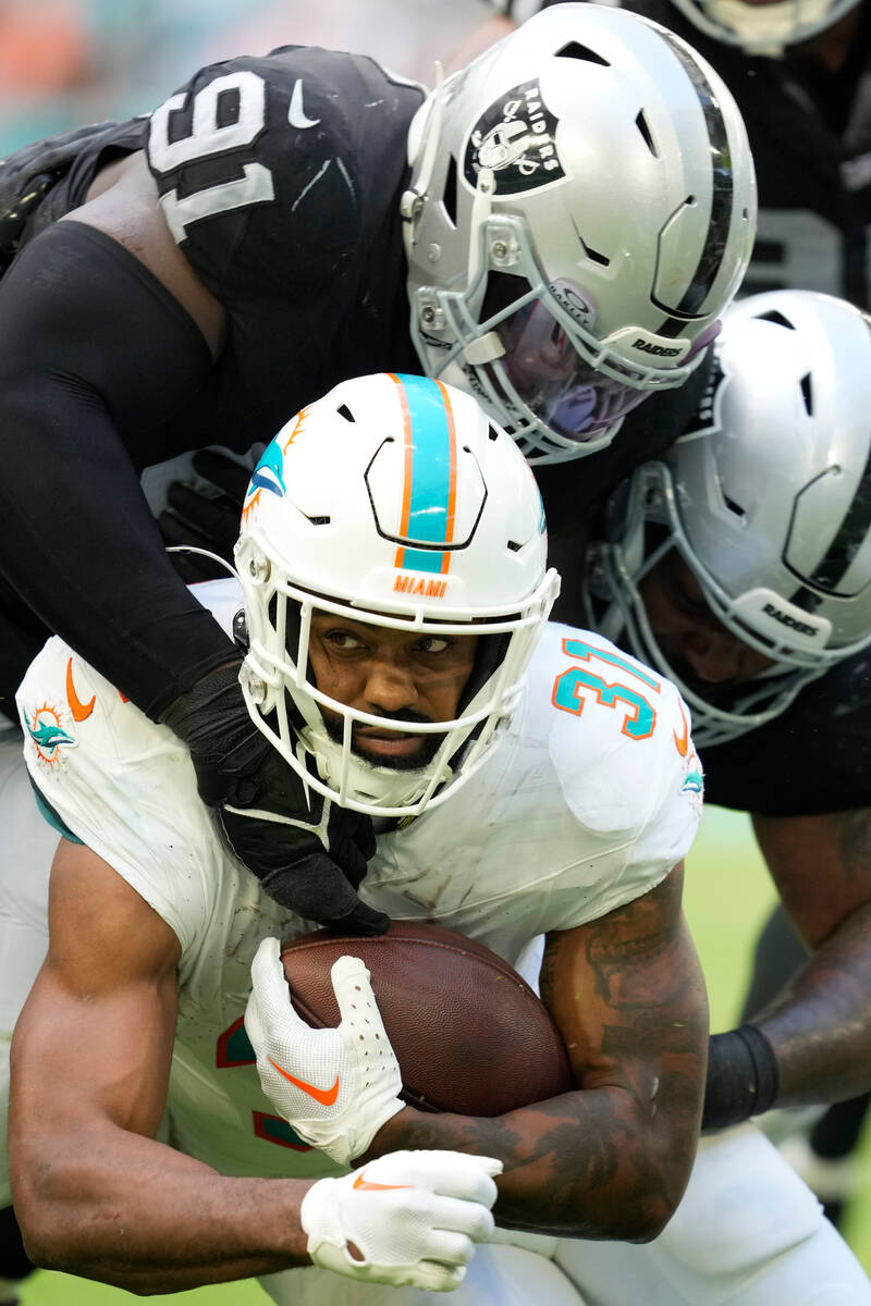 Miami Dolphins running back Raheem Mostert (31) is tackled by Las Vegas Raiders linebacker Robe ...