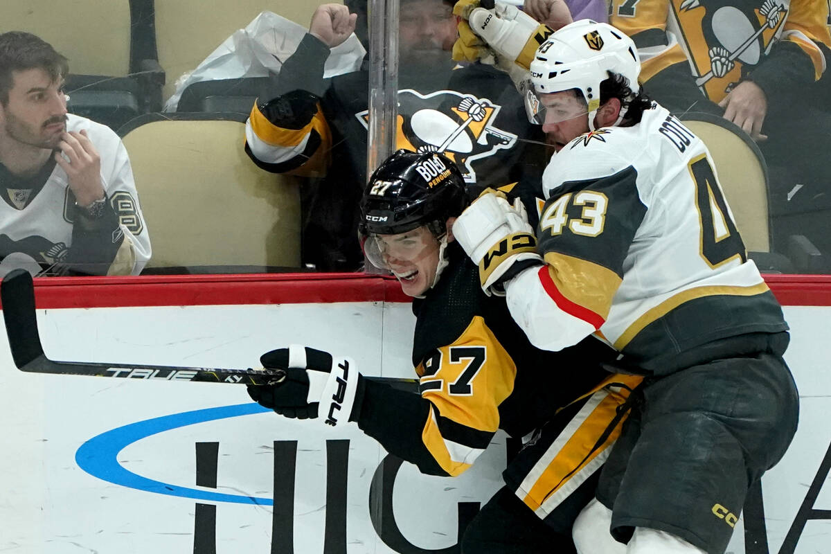 Vegas Golden Knights' Paul Cotter (43) checks Pittsburgh Penguins' Ryan Graves into the boards ...