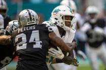 Miami Dolphins running back De'Von Achane (28) is tackled by Raiders cornerback Marcus Peters ( ...
