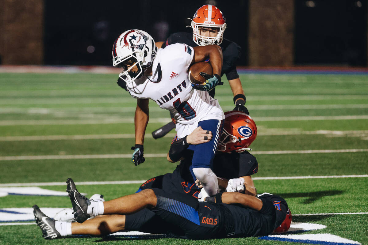 Liberty running back Brody Armani (6) tries his best to carry the ball as Bishop Gorman defensi ...