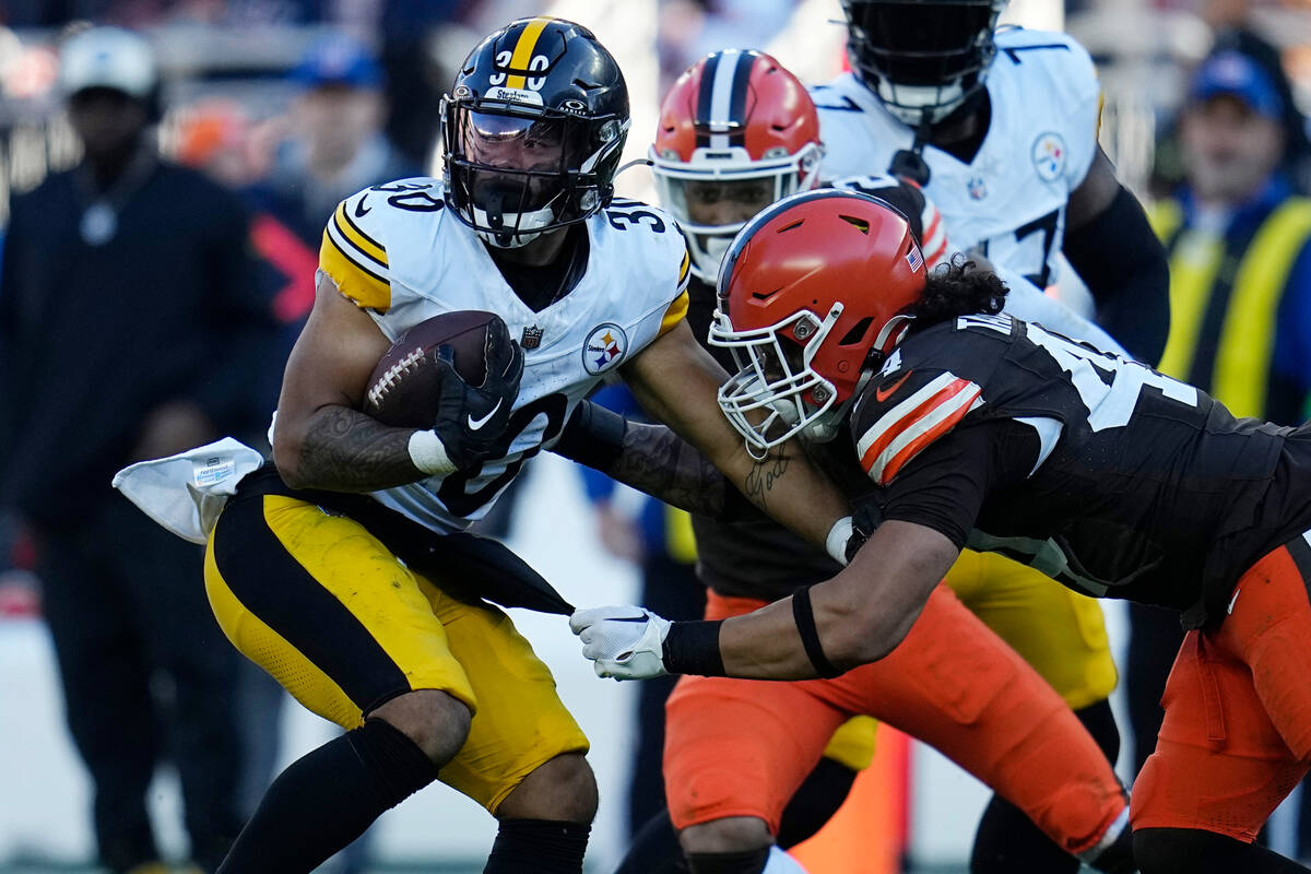 Pittsburgh Steelers running back Jaylen Warren (30) spins away from Cleveland Browns linebacker ...