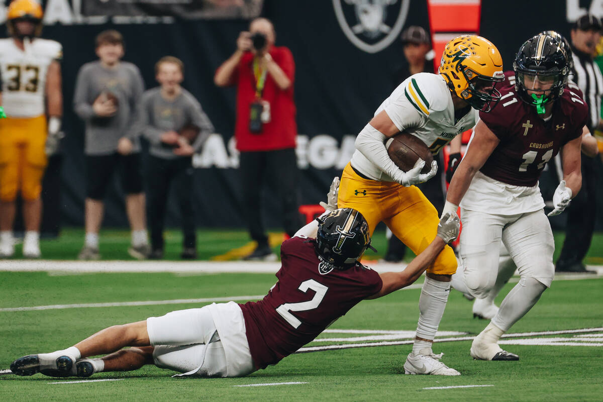 Faith Lutheran wide receiver Brandon Soares (2) tries to bring down a Bishop Manogue player dur ...