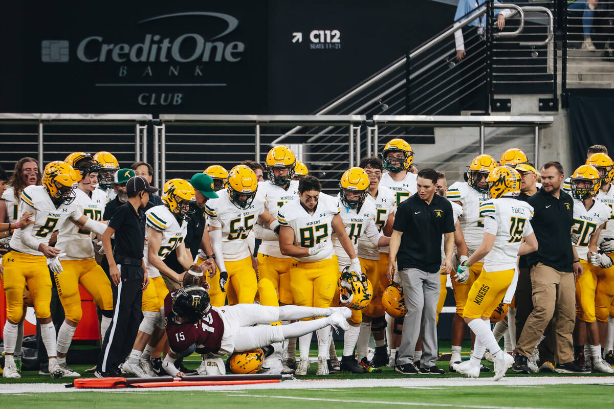 Faith Lutheran quarterback Alex Rogers dives into the Bishop Manogue sidelines during a class 5 ...