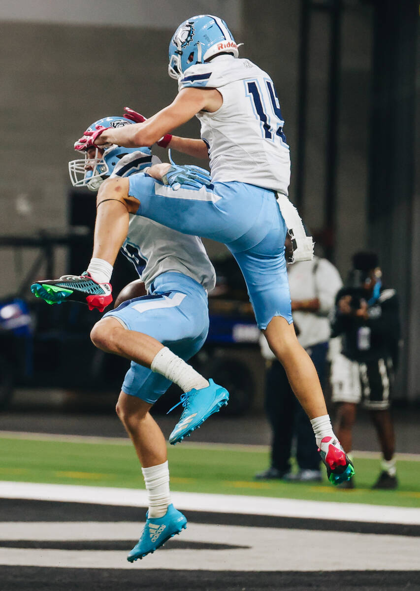 Centennial wide receiver Logan Weimer (16) celebrates a touchdown with teammate Mason Garza (15 ...