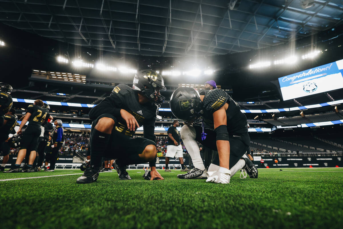 Sunrise Mountain running back Sam Seoane, left, comforts his teammate Thomas Marcellino after a ...