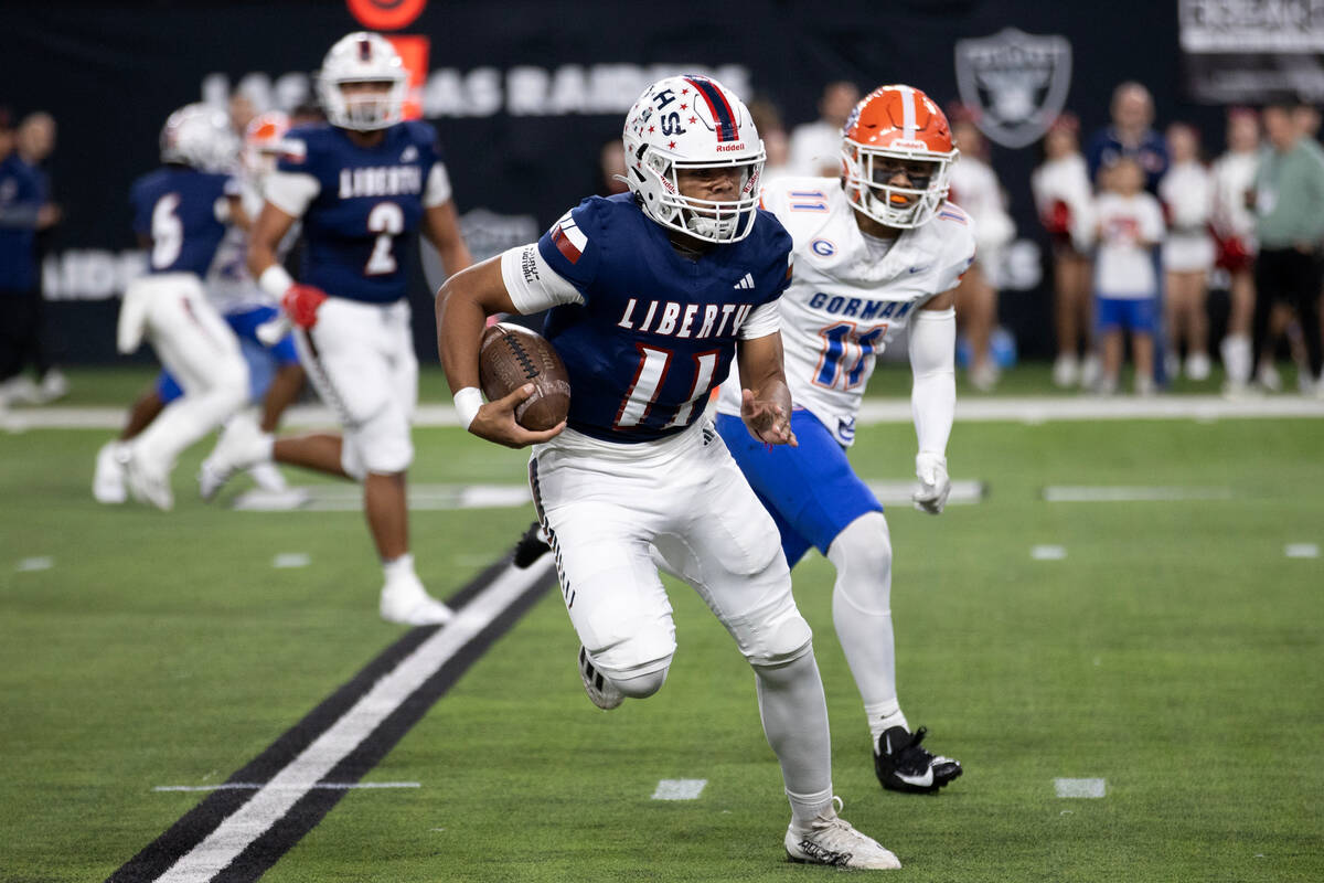 Liberty quarterback Tyrese Smith (11) runs the ball while Bishop Gorman inside linebacker Tamat ...