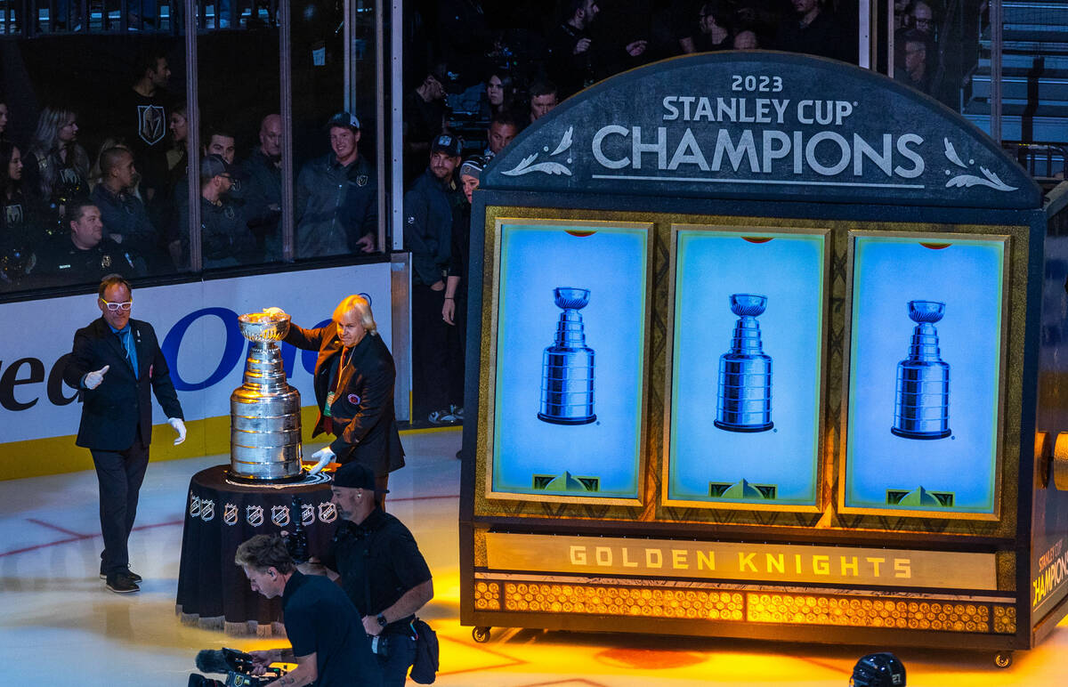 The keeper of the cup takes it away following the raising of the 2023 Stanley Cup Championship ...
