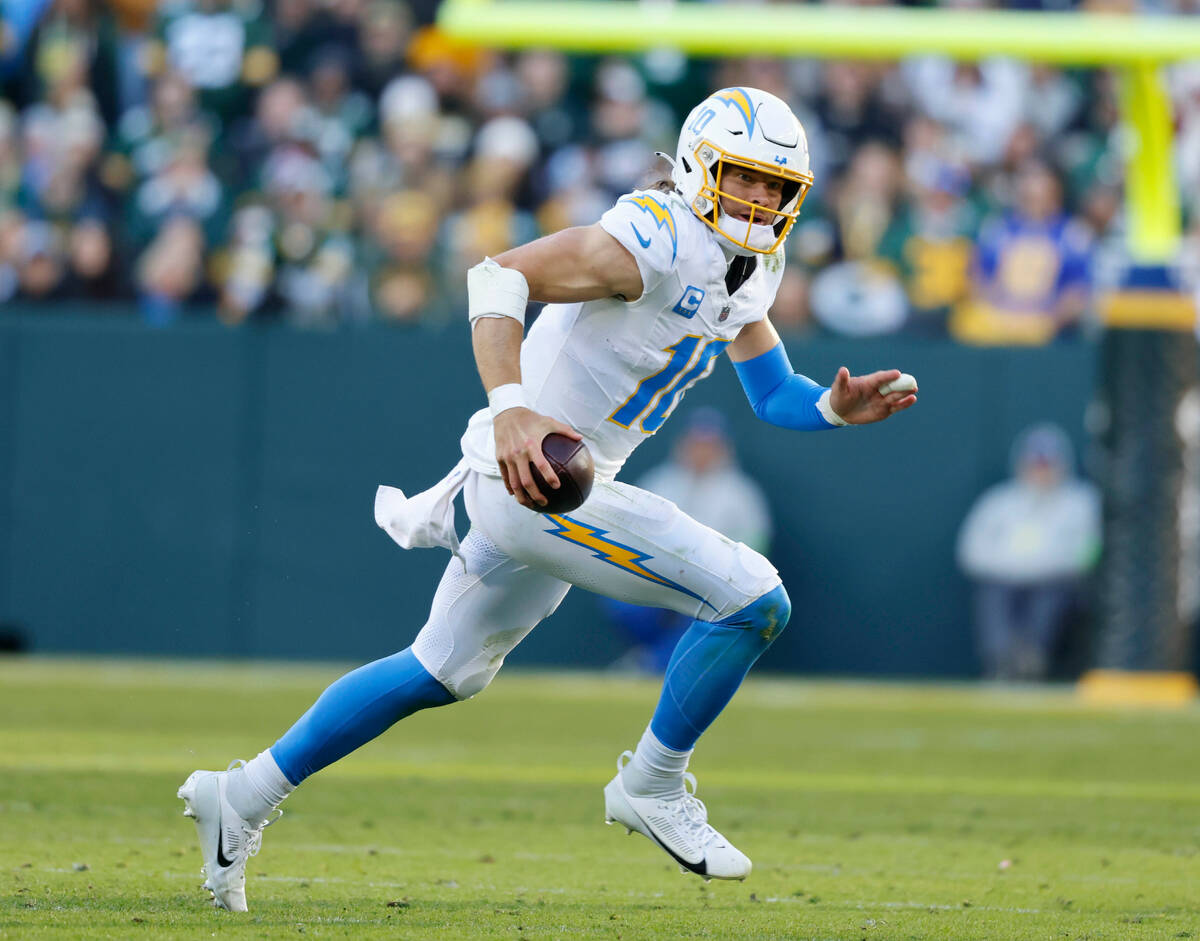 Los Angeles Chargers quarterback Justin Herbert (10) runs with the ball during an NFL football ...