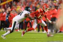 Kansas City Chiefs quarterback Patrick Mahomes (15) escapes the grip of Philadelphia Eagles def ...