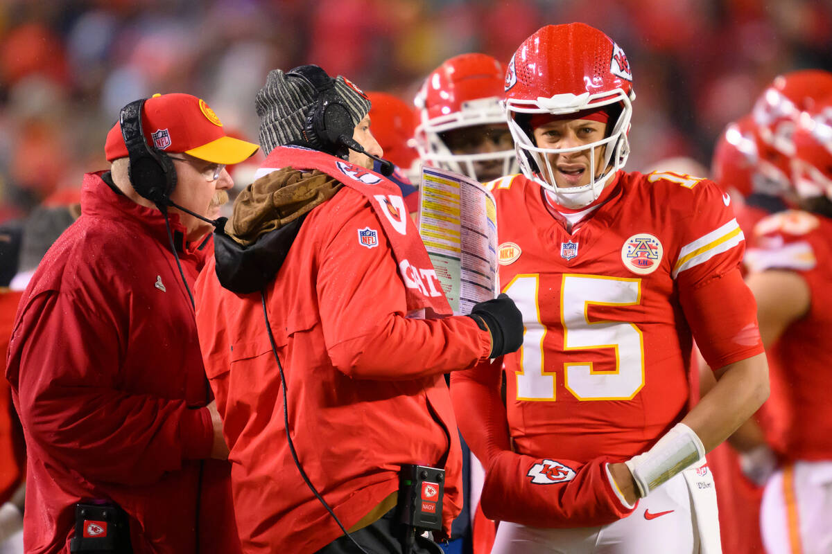 Kansas City Chiefs quarterback Patrick Mahomes (15) meets with offensive coordinator Matt Nagy, ...