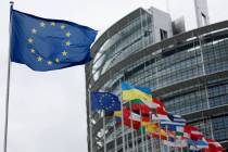 FILE - The European flag, left, flies at the European Parliament in Strasbourg, eastern France, ...