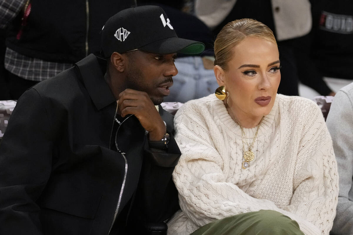 Singer Adele, right, talks to Rich Paul during the first half of an NBA basketball game between ...