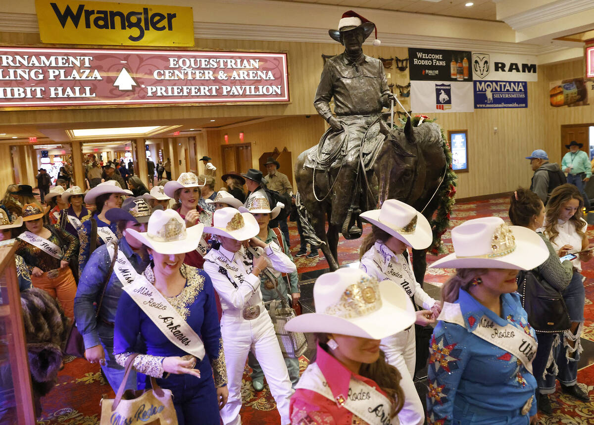 Miss Rodeo America title competitors walk past Benny Binion's statue, the man who brought the N ...