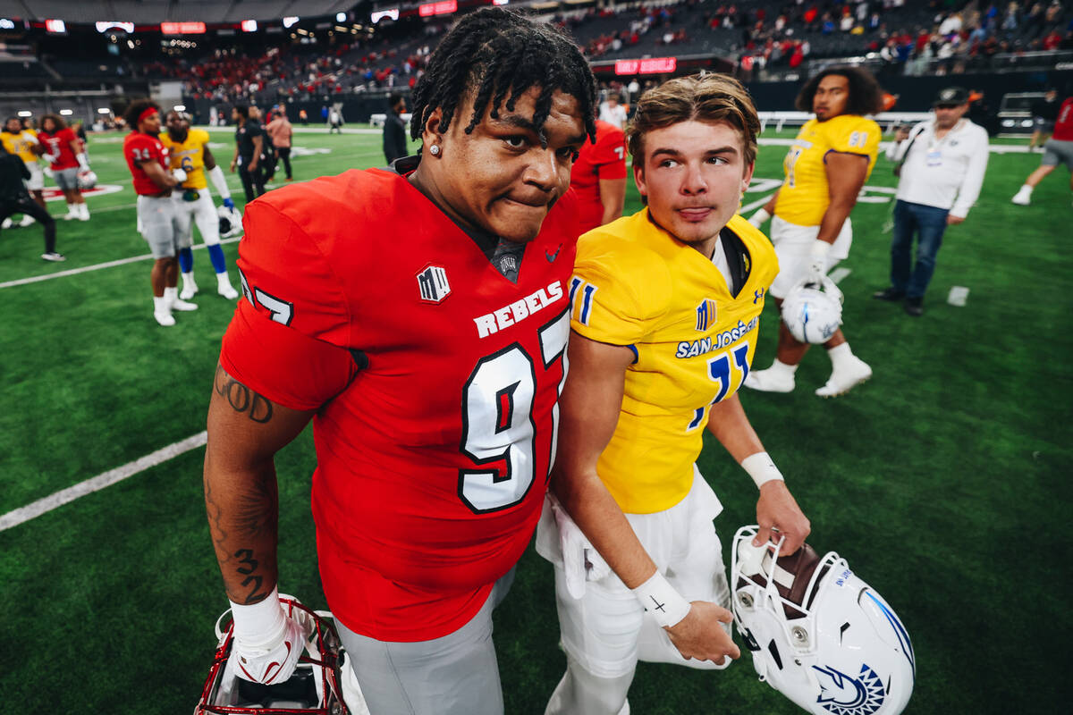 UNLV defensive lineman Nick Dimitris (97) and San Jose State place kicker Kyler Halvorsen (11) ...