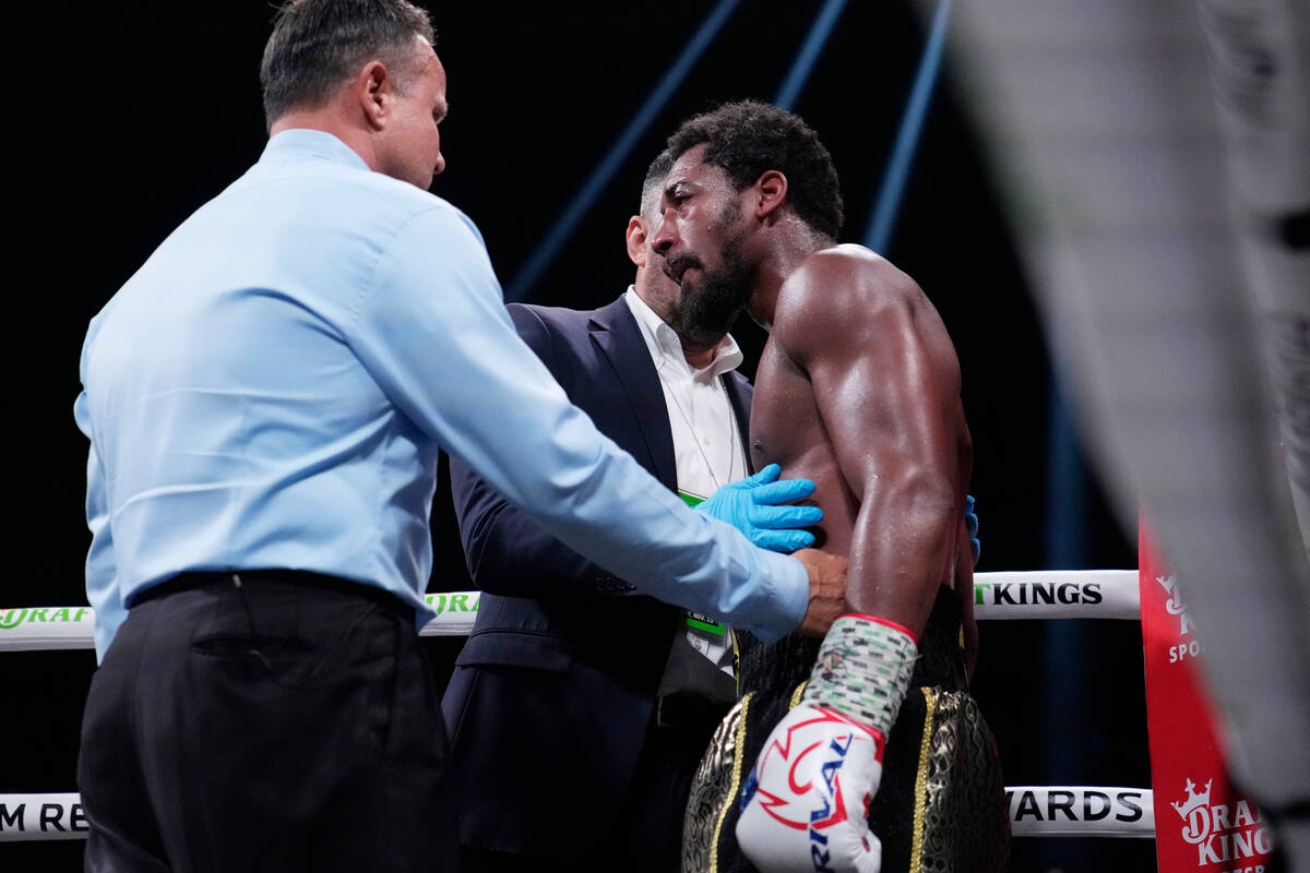 Officials check Demetrius Andrade during his super middleweight boxing match against David Bena ...