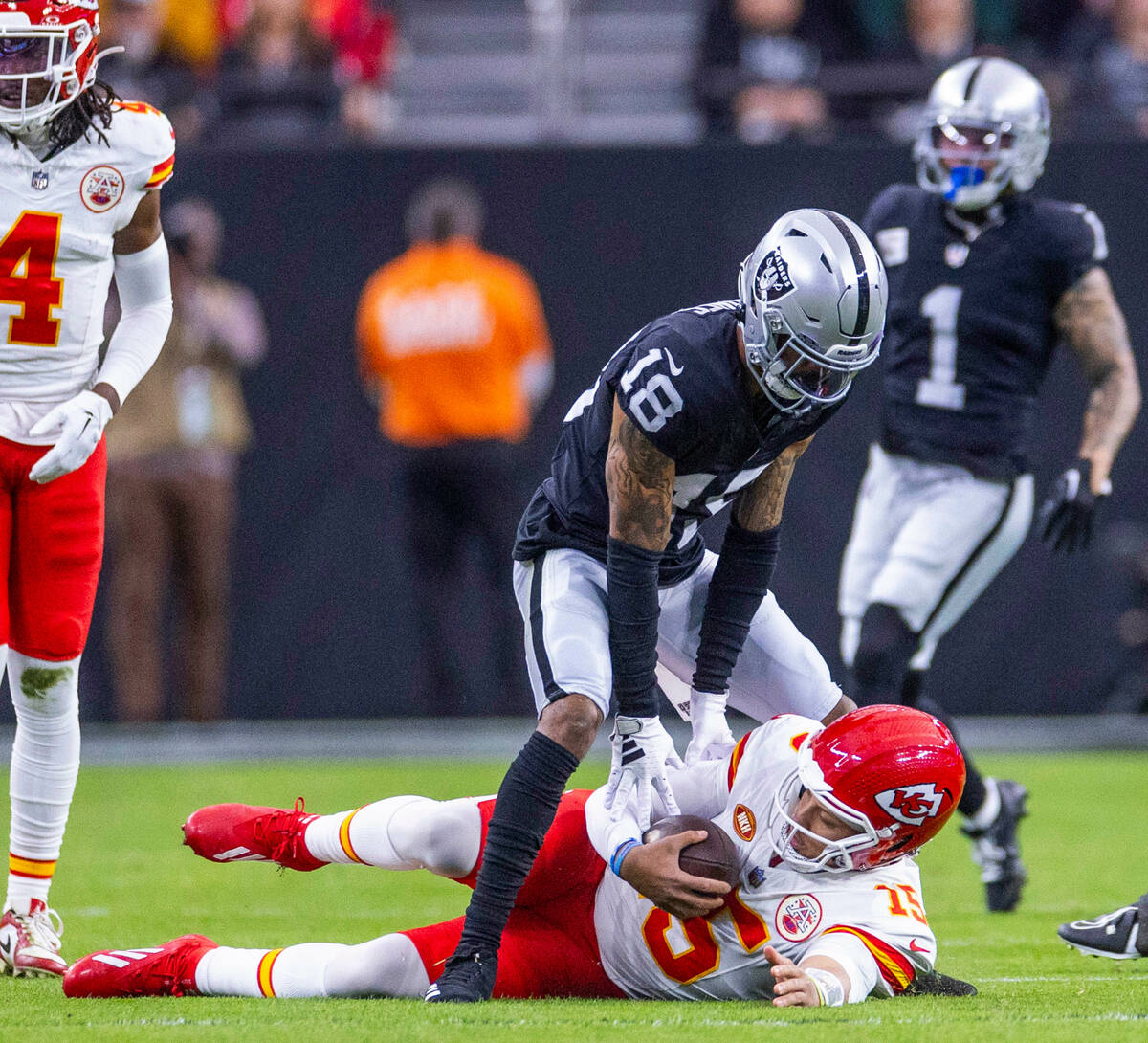 Kansas City Chiefs quarterback Patrick Mahomes (15) slides after a run beneath Raiders cornerba ...