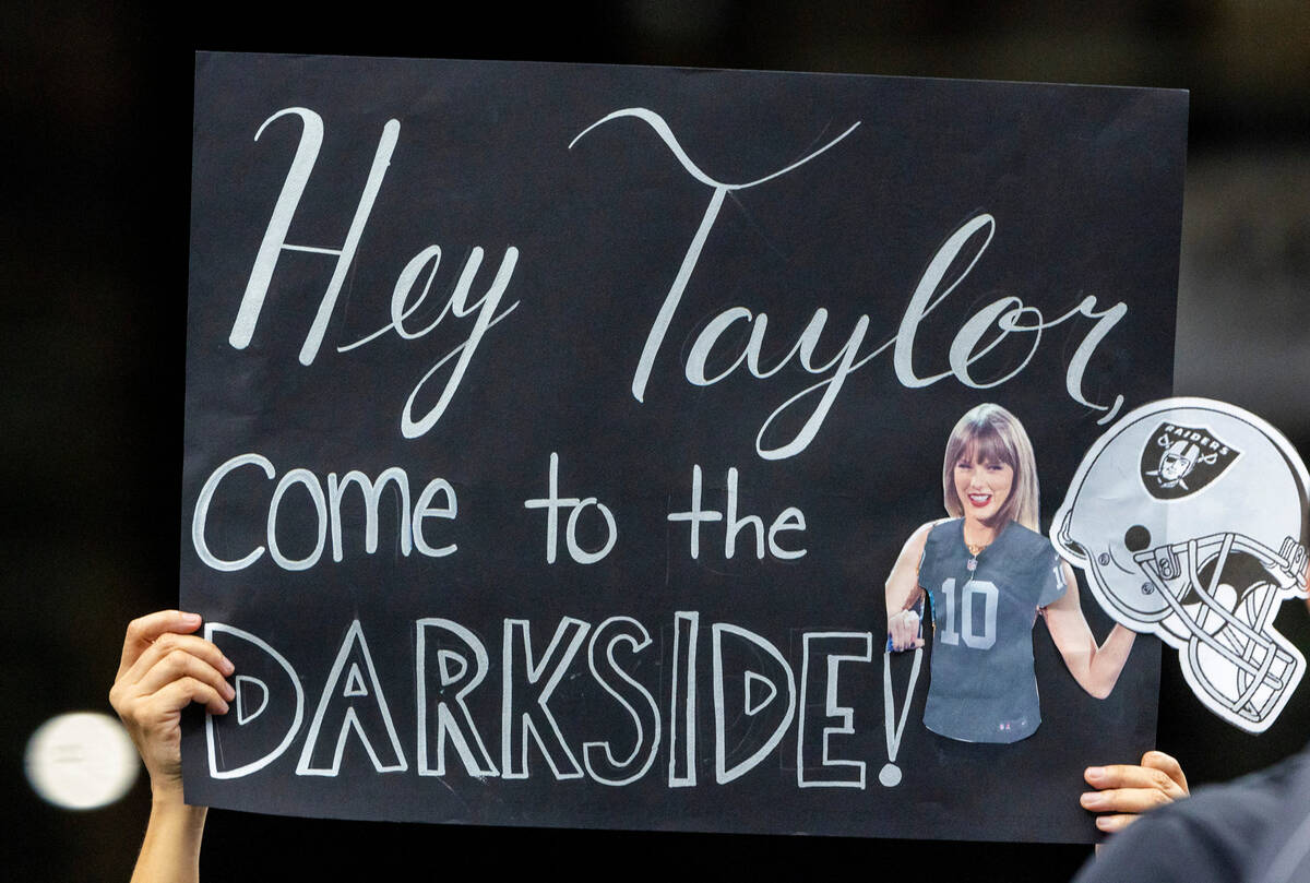 A Raiders fan holds a Taylor Swift poster in the first half of their NFL game against the Kansa ...