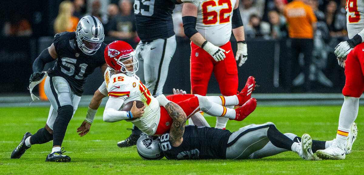 Kansas City Chiefs quarterback Patrick Mahomes (15) is sacked by Raiders defensive end Maxx Cro ...