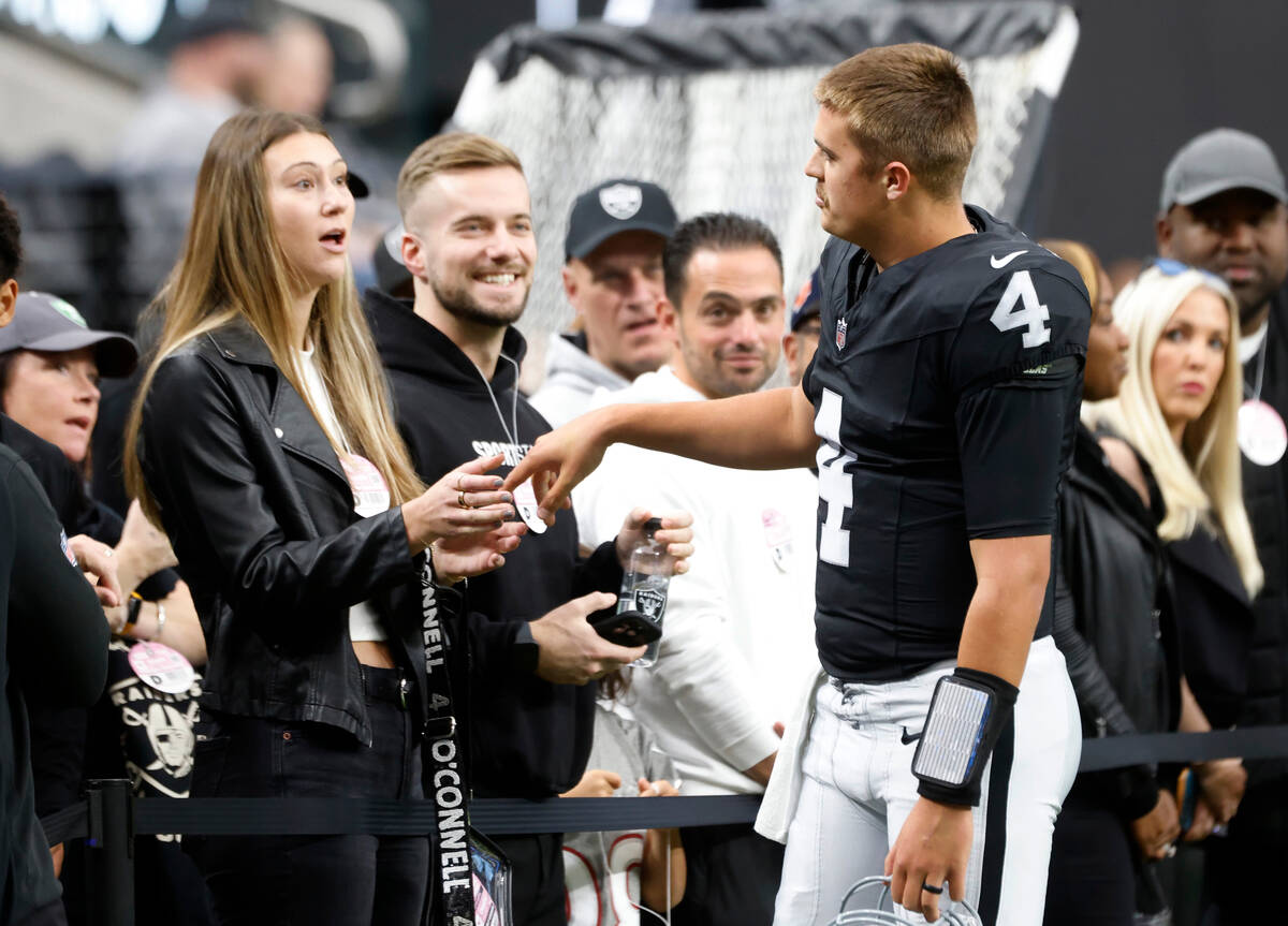 Raiders quarterback Aidan O'Connell (4) chats with his wife Jael as he takes the field to face ...