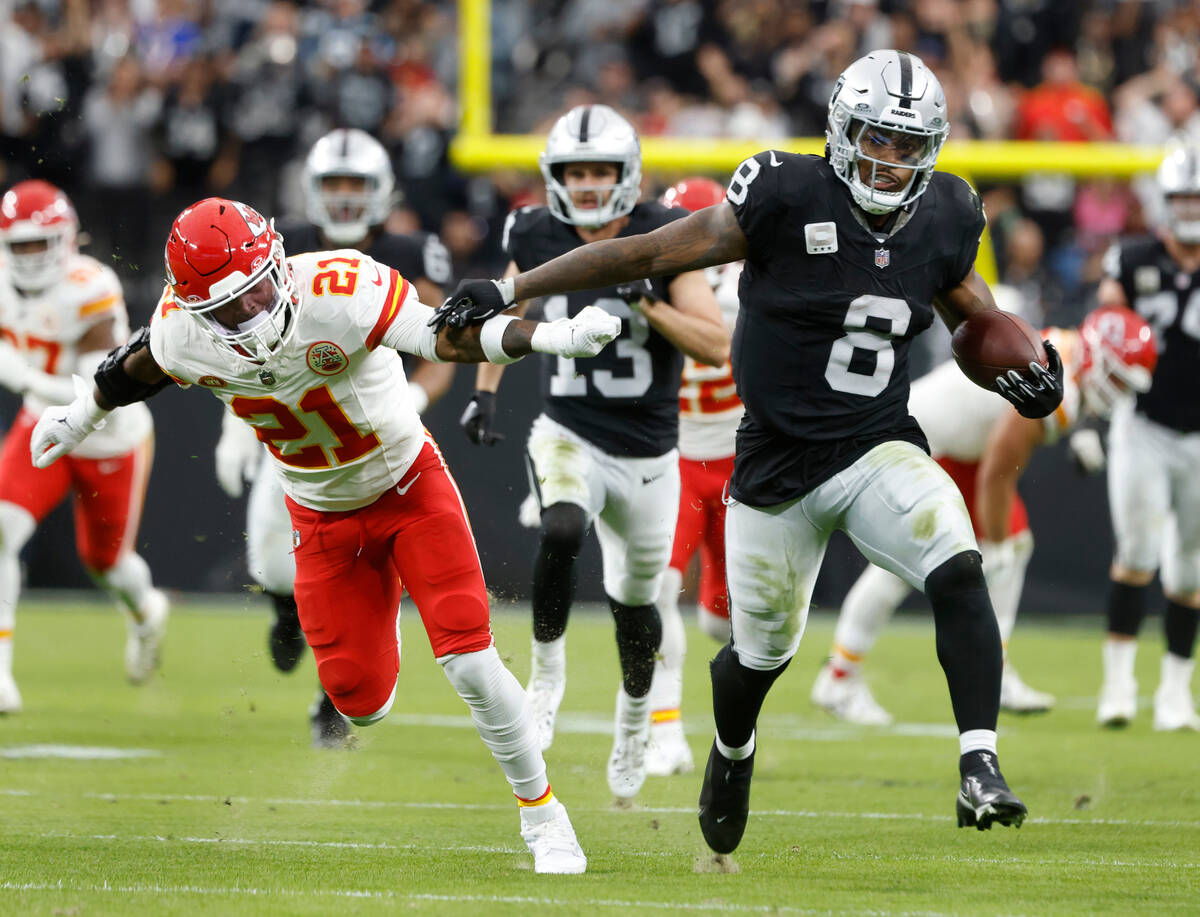 Raiders running back Josh Jacobs (8) pushes Kansas City Chiefs safety Mike Edwards (21) away as ...